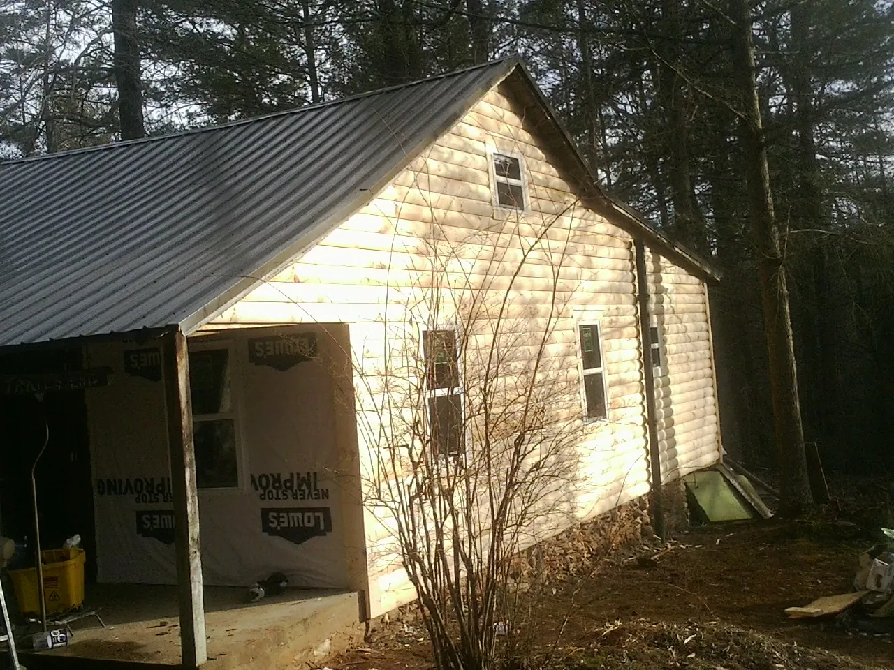 Log siding gable end under a dark metal roof edge in Mount Braddock