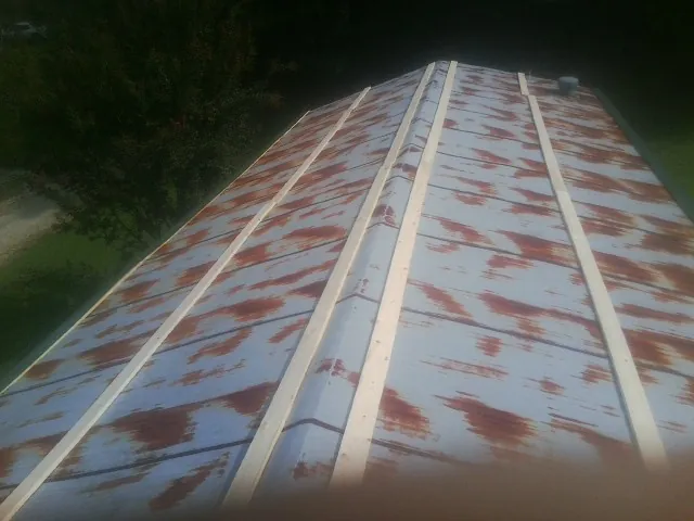 Rusted metal roof panels with new wood purlins before replacement — Storm Damage Roof Repair in Mount Braddock by Roofing Brothers