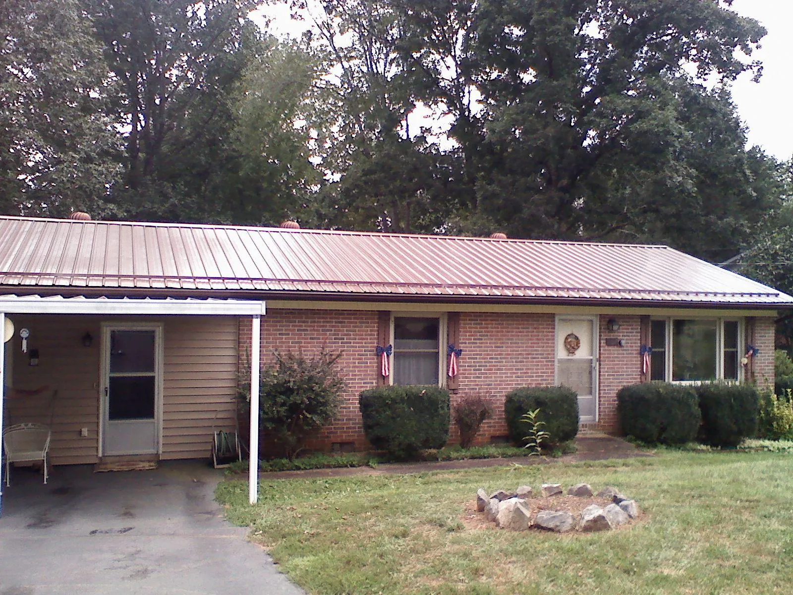 Bronze metal roof and carport on a brick ranch home — Roof Repair work by our crew in Mount Braddock